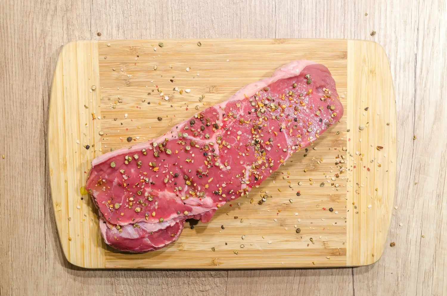 Steak assaisonné de poivre fraîchement moulu avec un moulin Iron-Mills