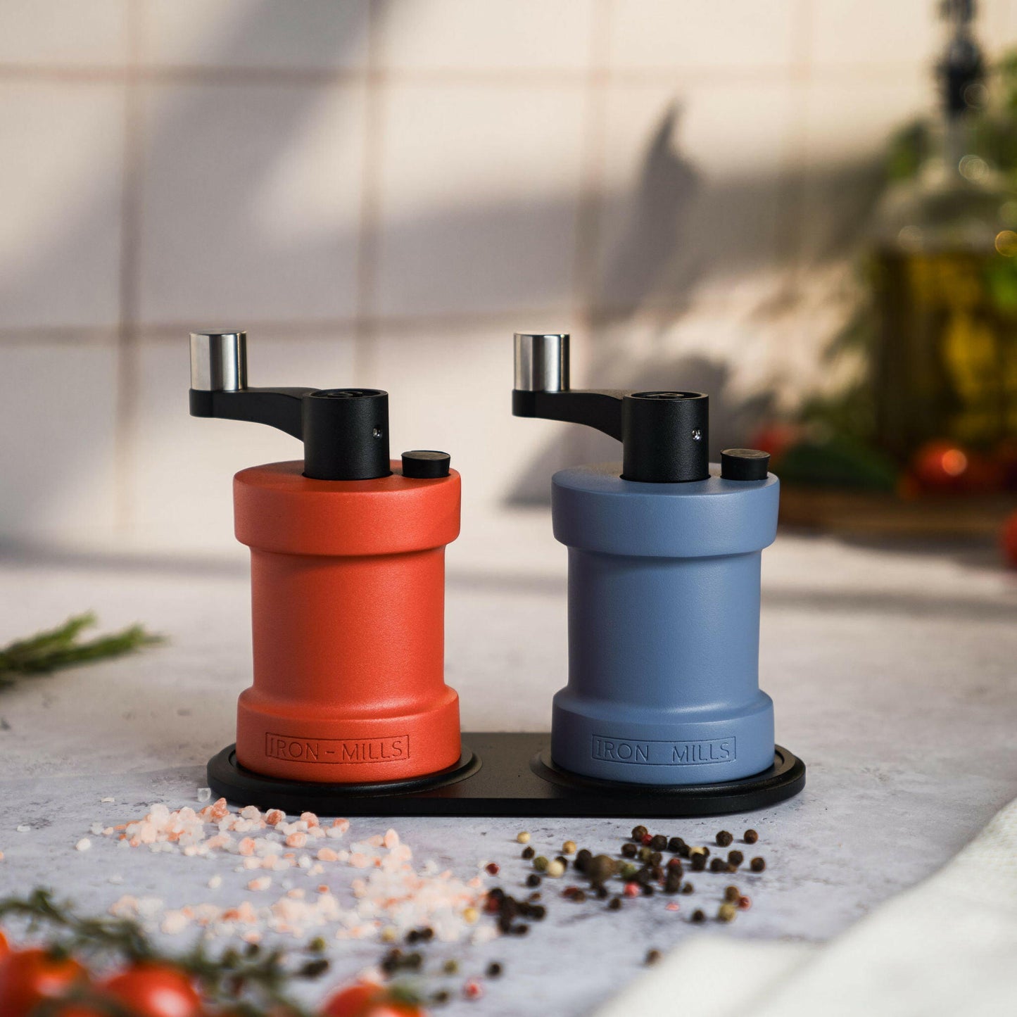 Iron-Mills coral red and pigeon blue salt and pepper mills displayed on a high-quality rest with a unique colour contrast