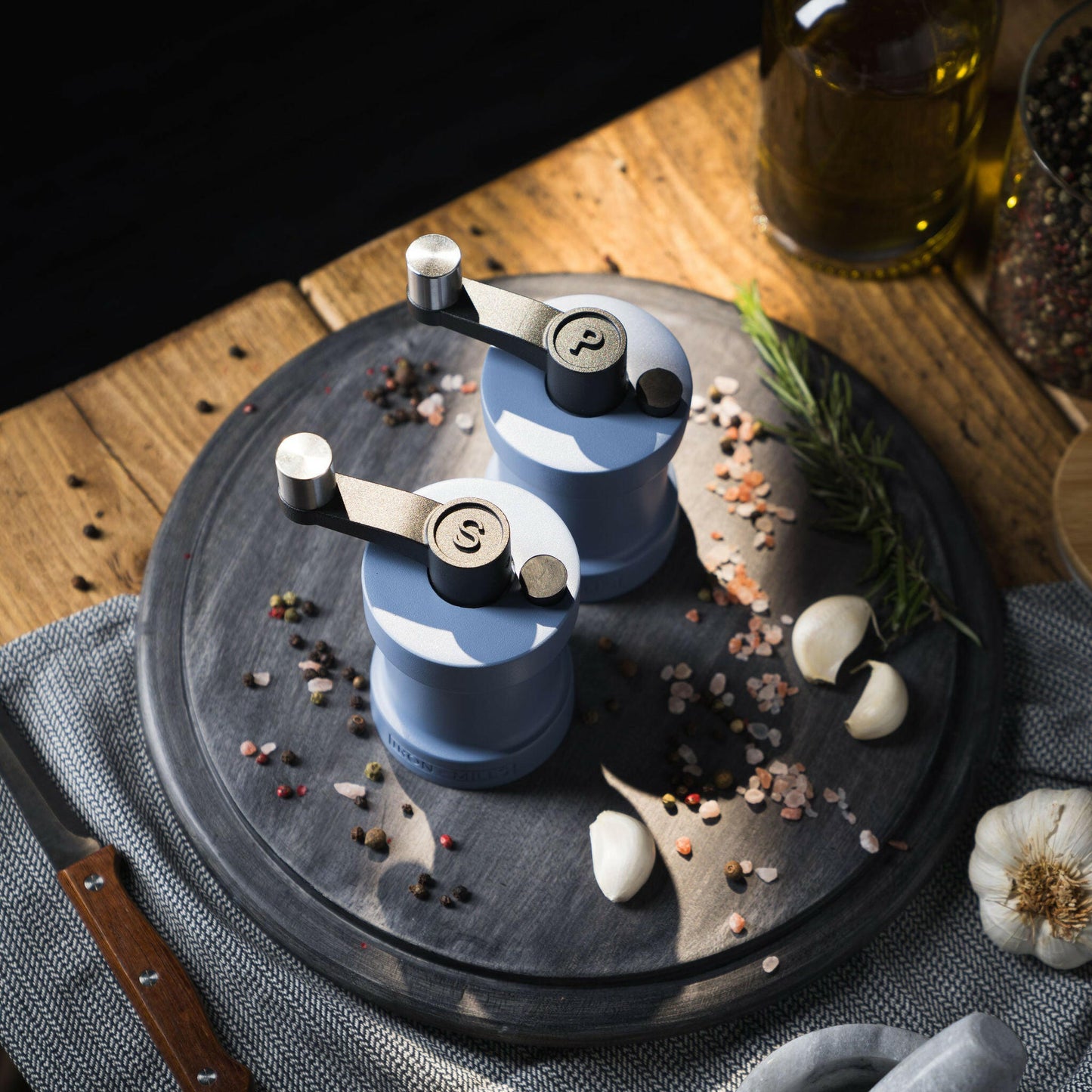 Iron-Mills pigeon blue salt and pepper mills on a chopping board in a serene kitchen with condiments