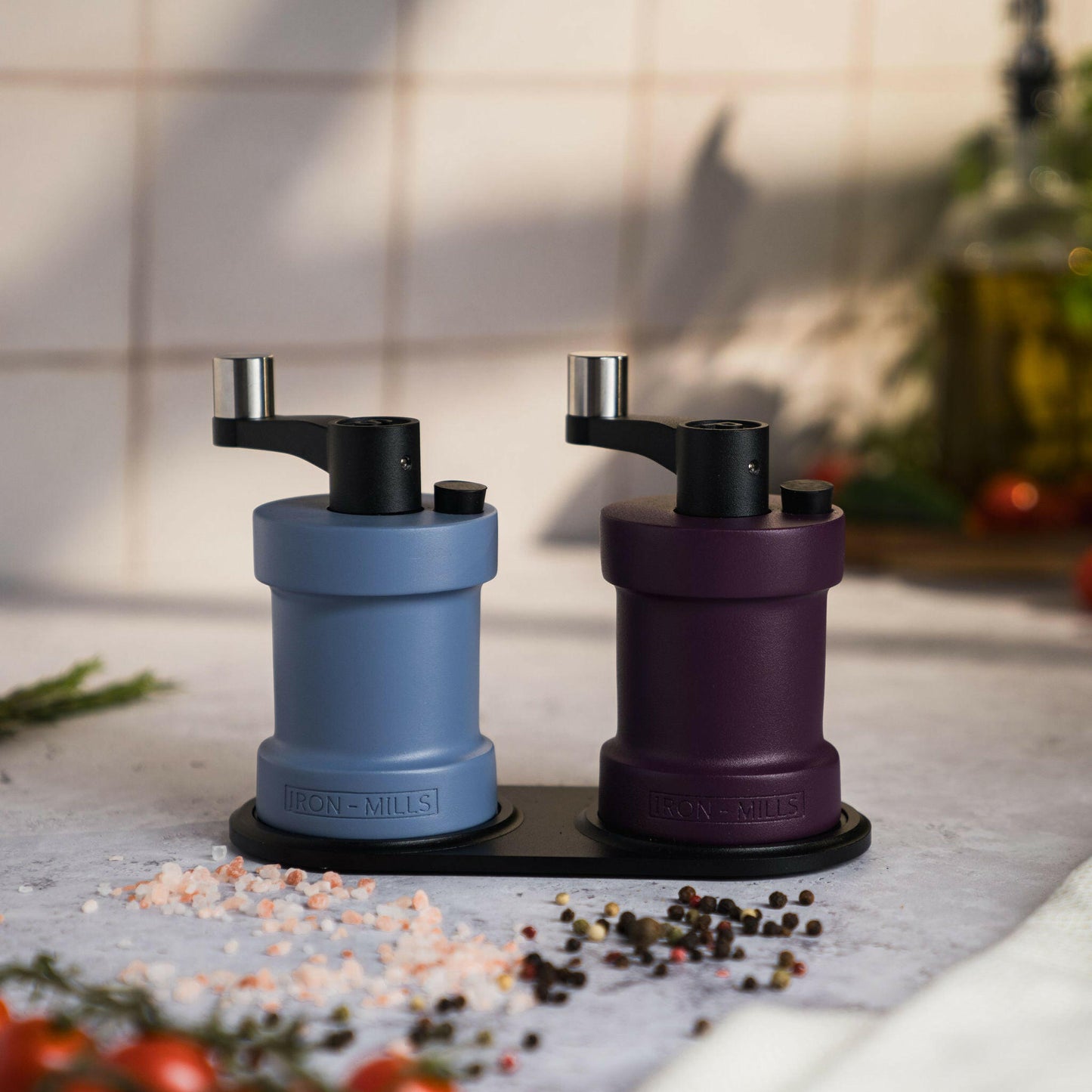 Iron-Mills purple and pigeon blue salt and pepper mills displayed on a mill rest for a stylish and modern presentation